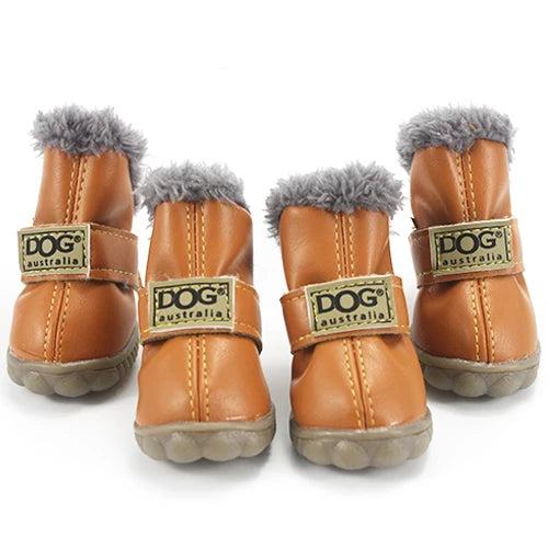 Four light brown leather dog boots with grey fur lining, adjustable straps, and non-slip soles.
