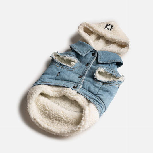 Light blue denim dog jacket with soft white Sherpa lining, a cozy hood, and stylish distressed details. The jacket includes button closures and arm holes, designed for warmth and comfort.