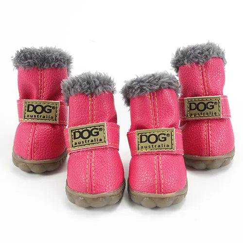 Four pink leather dog boots with grey fur lining, adjustable straps, and non-slip soles.