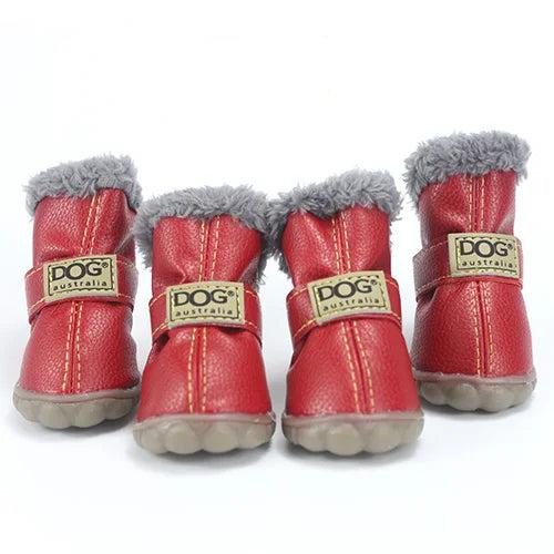 Four red leather dog boots with grey fur lining, adjustable straps, and non-slip soles.